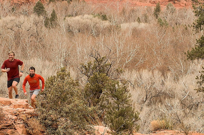 Runners in red gear, desert.