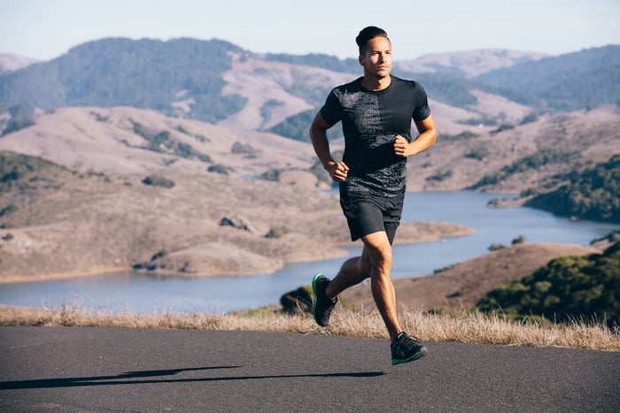 Jogger in mountains; brand shoes.