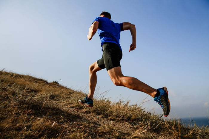 Nike runner on sunny hill.