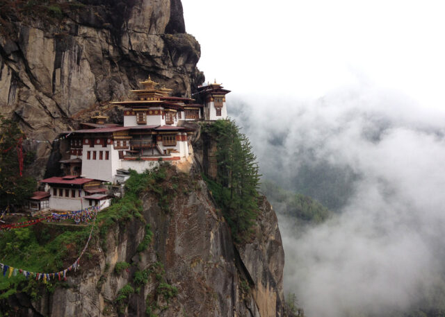 Bhutanese monastery on a misty cliffside.