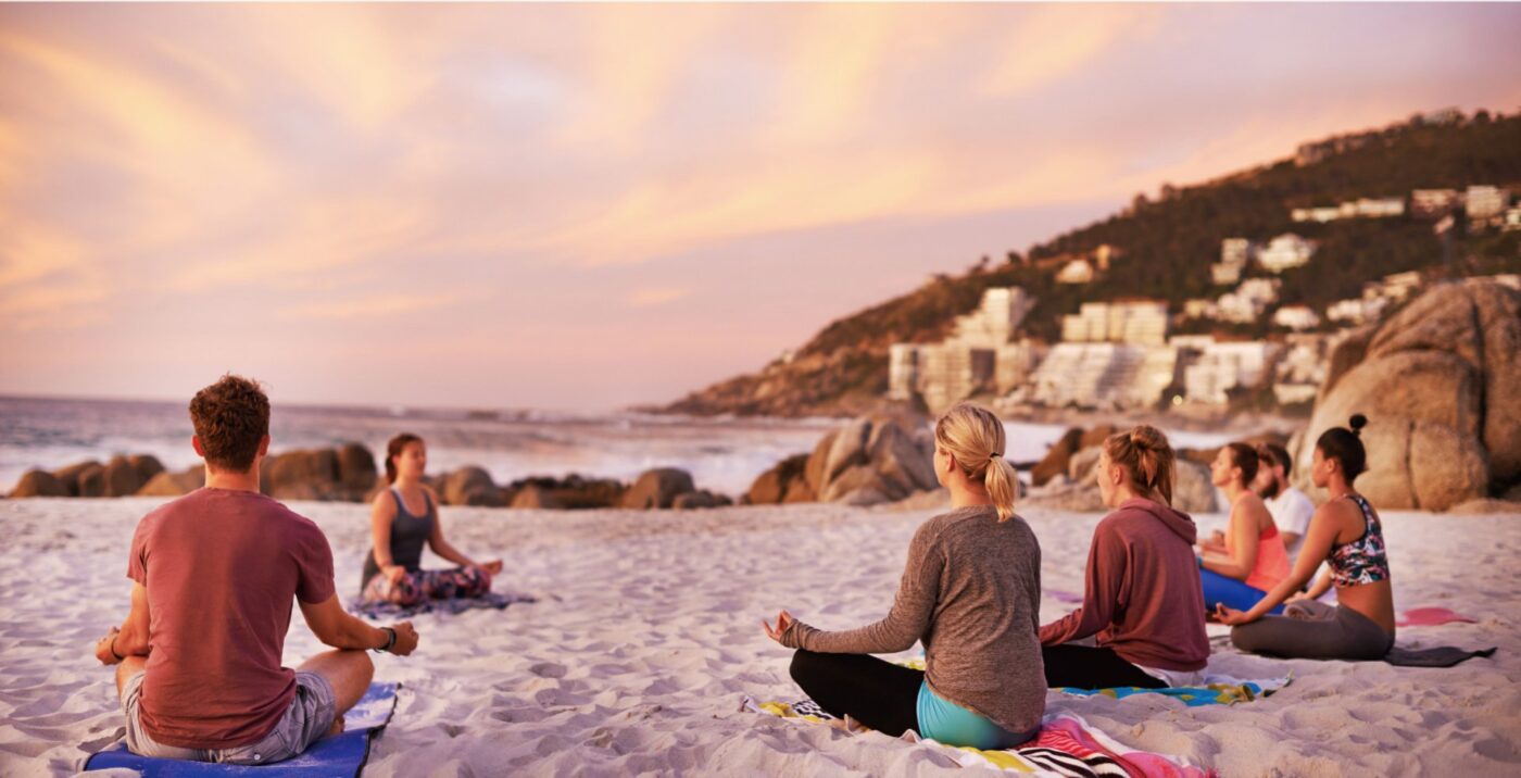 People meditating on a beach