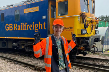 British trainspotter poses in front of GB Railfreight.