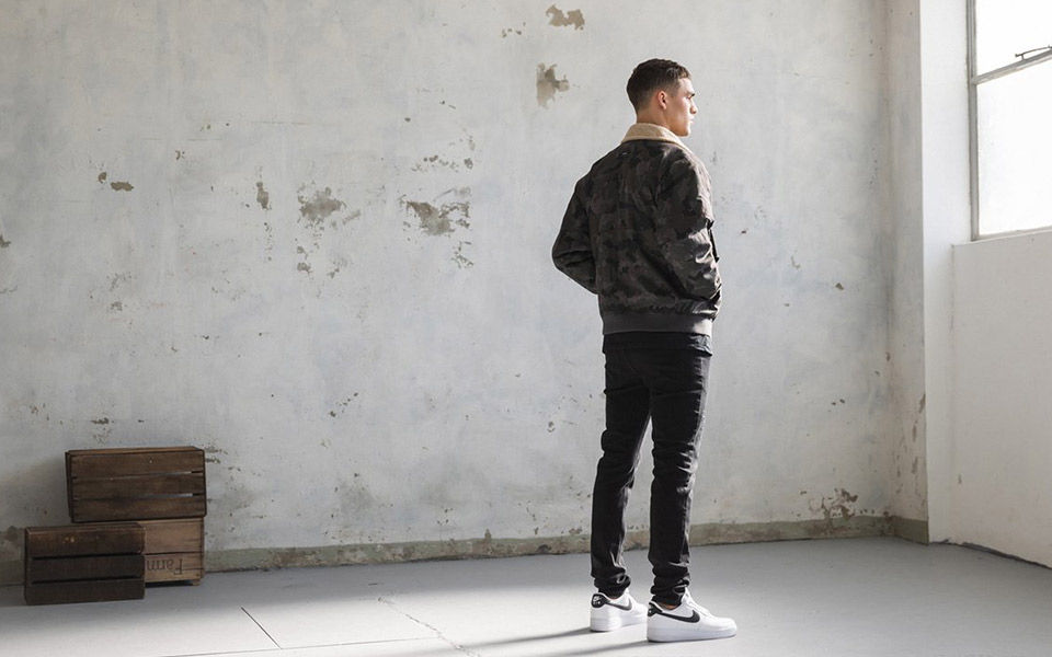 Person models Australian menswear with urban backdrop.