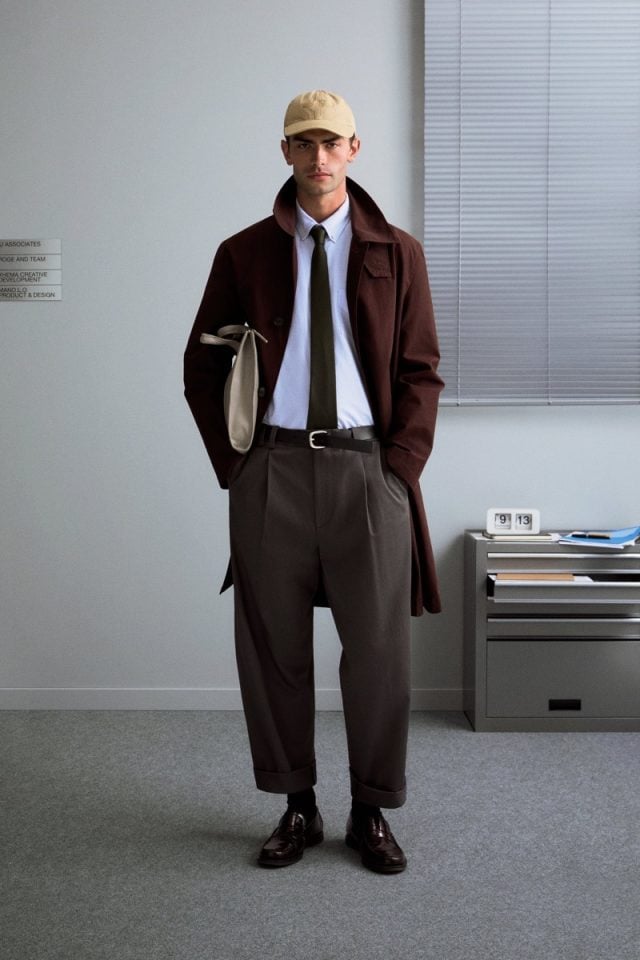 A model wearing white shirt and tie combined with long coat, an example of smart work wear