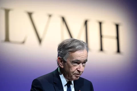 Bernard Arnault speaks elegantly with LVMH backdrop.