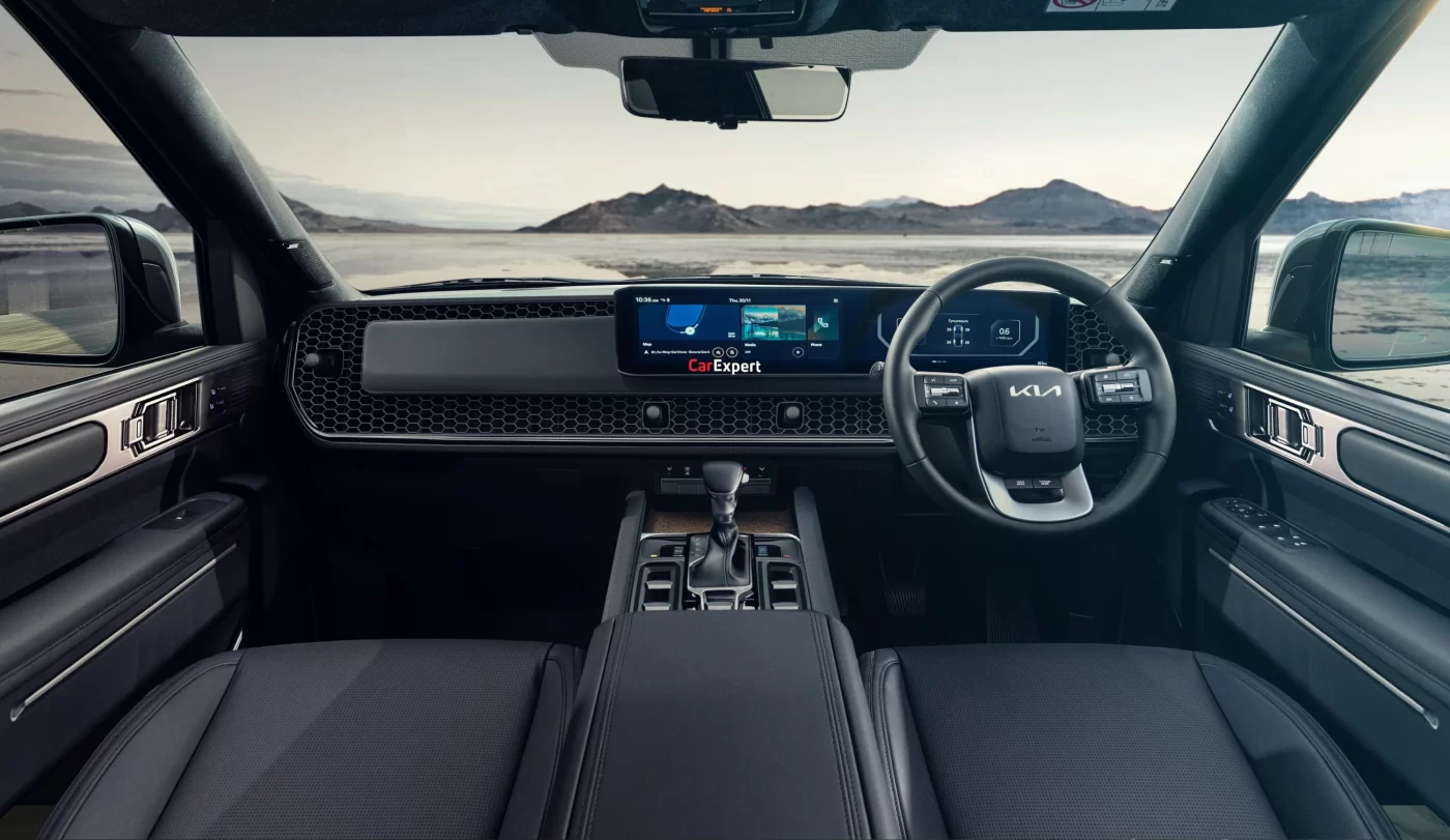 Kia Tasman's dashboard features digital screen; Australian landscape outside.