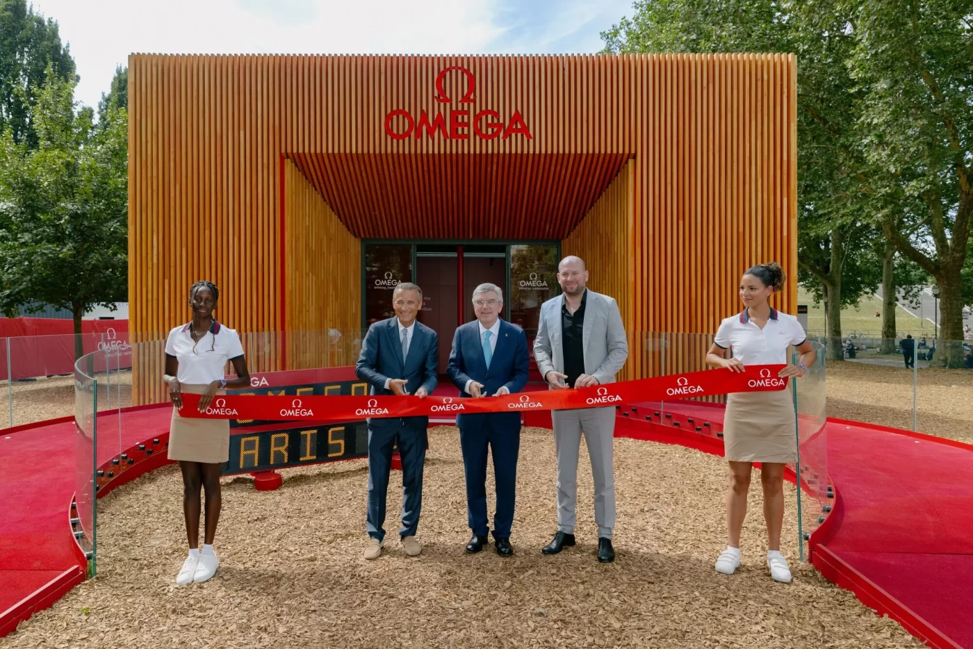 Four people at Omega building ribbon cutting.